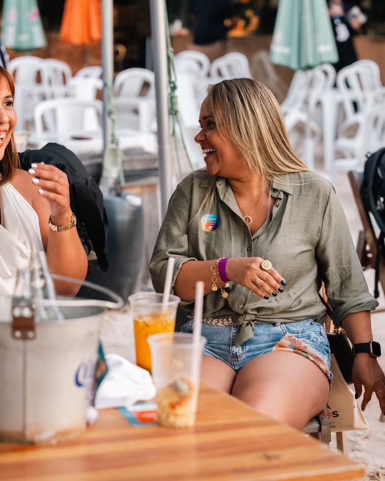 Duas participantes conversando e rindo na mesa