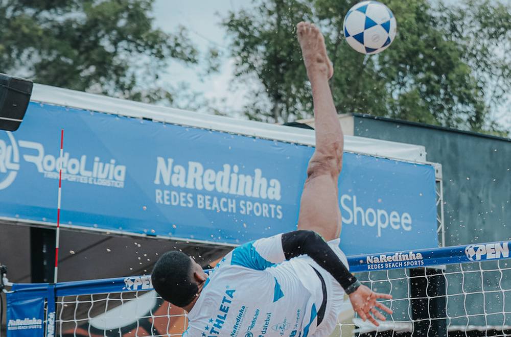 Atleta atacando no alto durante partida do Campeonato Brasileiro de Futevôlei